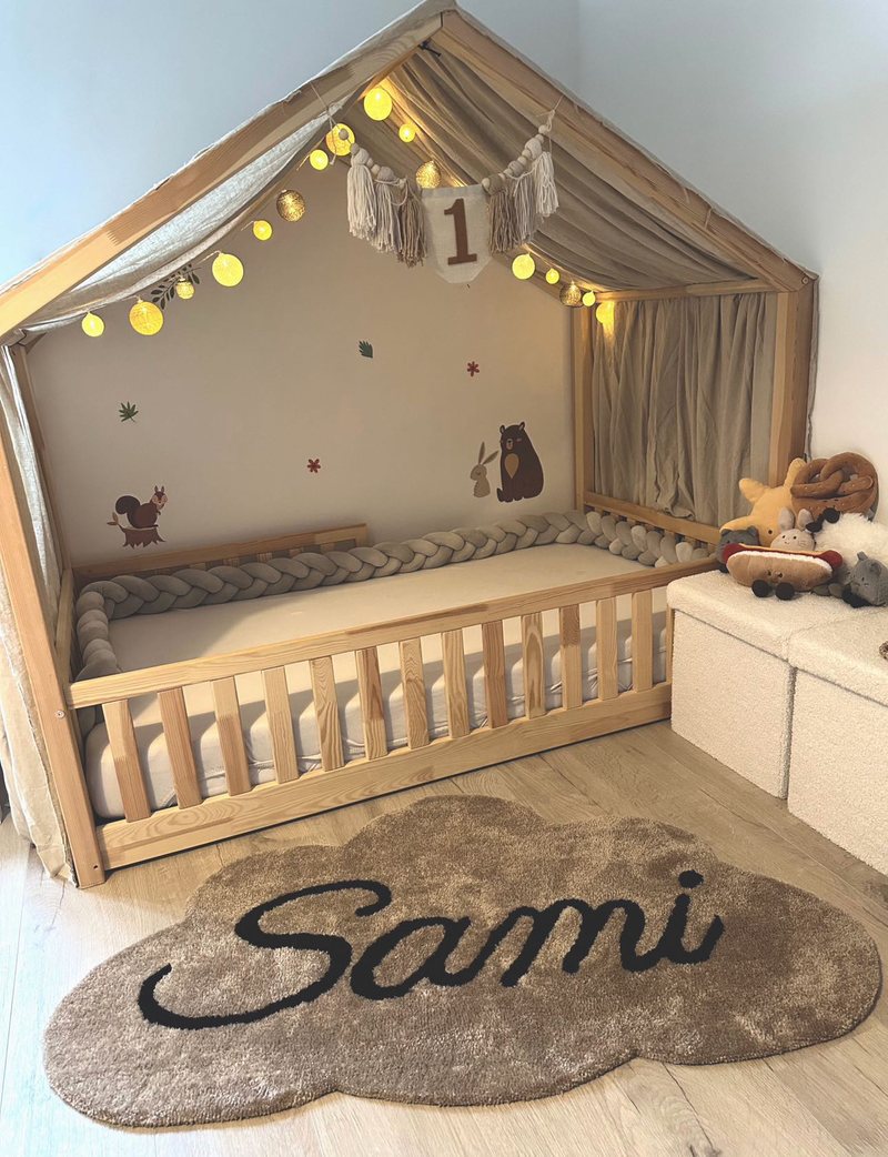 Tapis en laine tufté main en forme de nuage, au prénom Sami, au pied d’un lit cabane